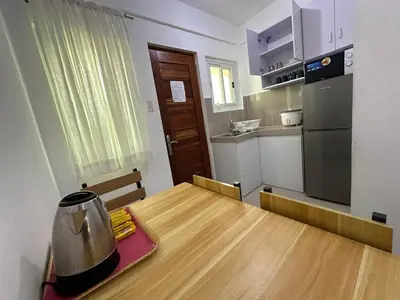 a small kitchen with a wooden table and a refrigerator at B&CH RESIDENCE Transient in Calamba