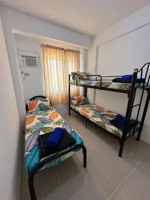 a bedroom with two bunk beds and a window at B&CH RESIDENCE Transient in Calamba