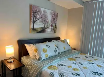 a bedroom with a bed and a painting on the wall at Condo at the heart of BGC located at Uptown Parksuites in Manila