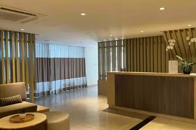 a hotel lobby with a reception desk and a chair at Condo at the heart of BGC located at Uptown Parksuites in Manila