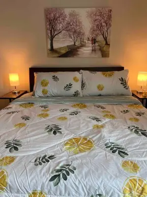 a bed with yellow and green sheets and pillows at Condo at the heart of BGC located at Uptown Parksuites in Manila