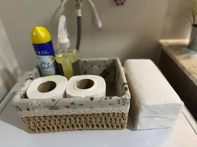 a bathroom with a basket with toilet paper and a sink at 10F Luxury 1BR at Park Mckinley West near Venice Mall in Manila