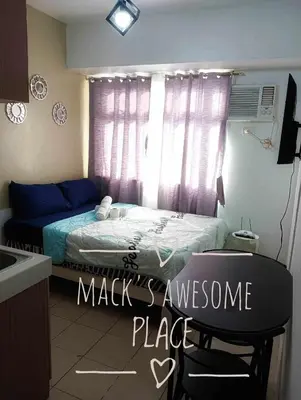 a bedroom with a bed and a table and a chair at Macks Awesome Place 22 Fast Wifi Premium Netflix in Manila
