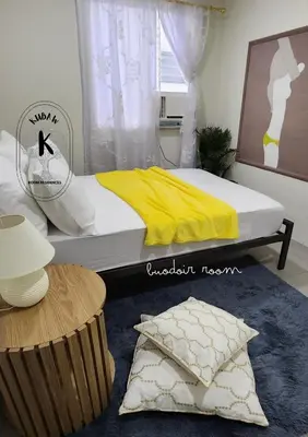 a bedroom with a bed with yellow sheets and a table at Boudoir Hideaway close to Araneta Center in Manila