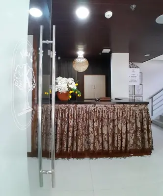 a table with a curtain and a vase of flowers at Boudoir Hideaway close to Araneta Center in Manila