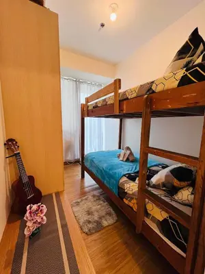 a bedroom with two bunk beds and a guitar at Azure Urban Resort Residences in Manila