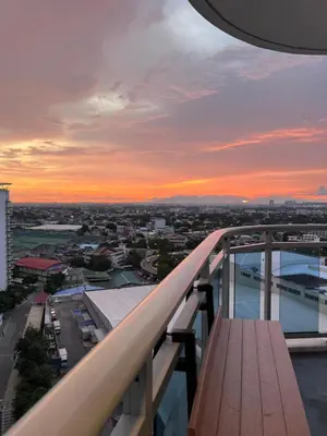 a bench on the balcony of a building at sunset at Azure Urban Resort Residences in Manila