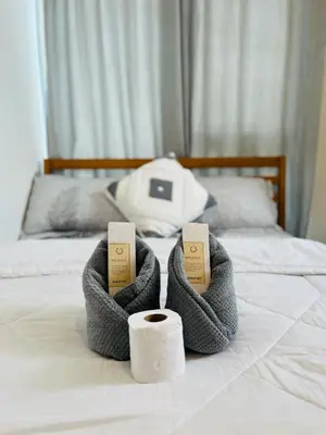 a pair of towels and a roll of toilet paper on a bed at Azure Urban Resort Residences in Manila
