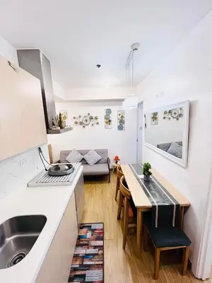 a kitchen and living room with a sink and a table at Azure Urban Resort Residences in Manila