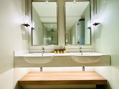 a bathroom with two sinks and a large mirror at The Hotel at Acqua Residences Tower 2 in Manila