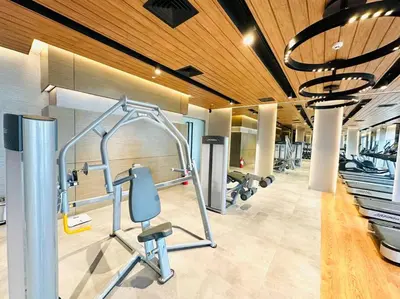 a gym with a treadmill and a row of exercise bikes at The Hotel at Acqua Residences Tower 2 in Manila
