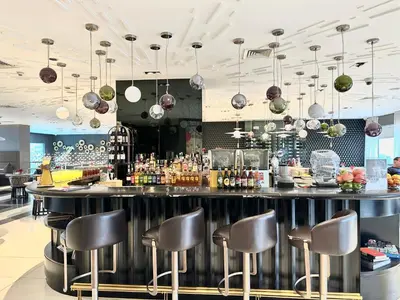 a bar in a restaurant with stools at The Hotel at Acqua Residences Tower 2 in Manila