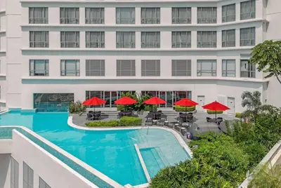 an aerial view of a hotel with a pool and red umbrellas at The Hotel at Acqua Residences Tower 2 in Manila