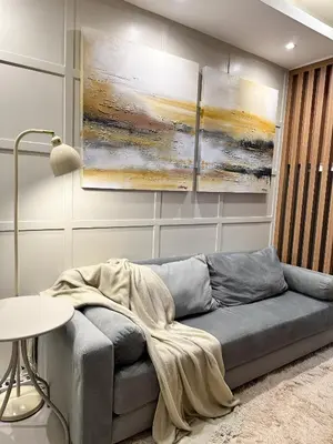 a living room with a couch and paintings on the wall at Cozy and Aesthetic Condo at Shore 3 in MOA, Pasay in Manila