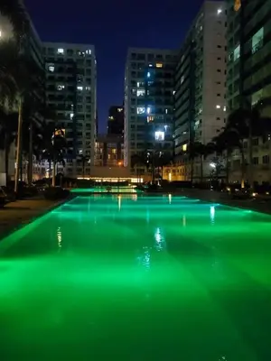 a pool of green illumination in a city at night at Sea Residences by-Azenith in Manila