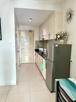 a kitchen with a stainless steel refrigerator and cabinets at Sea Residences by-Azenith in Manila