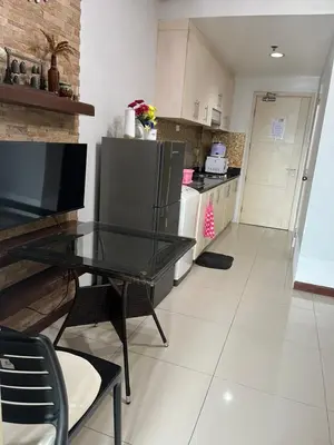 a kitchen with a glass table and a kitchen with a counter at Sea Residences by-Azenith in Manila