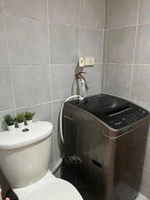 a bathroom with a toilet and a washer at Sea Residences by-Azenith in Manila