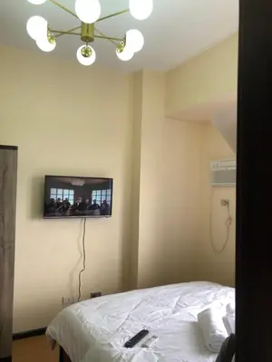 a bedroom with a bed with a tv on the wall at The RADIANCE MANILA BAY in Manila