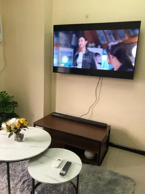 a living room with two tables and a tv on the wall at The RADIANCE MANILA BAY in Manila