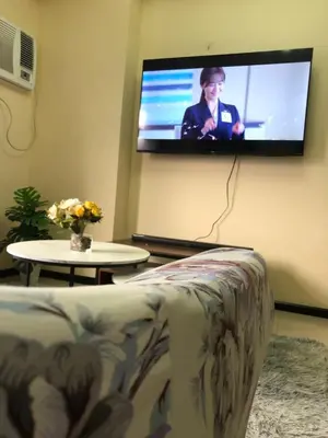 a living room with a couch and a tv on the wall at The RADIANCE MANILA BAY in Manila