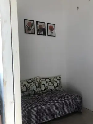 a room with a couch with four pictures on the wall at SOUTH Residence Condotel in Manila