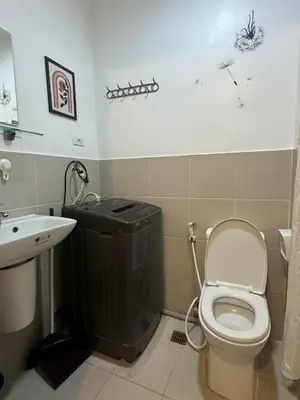 a bathroom with a toilet and a sink at SOUTH Residence Condotel in Manila