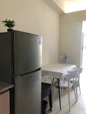 a kitchen with a stainless steel refrigerator and a table at SOUTH Residence Condotel in Manila