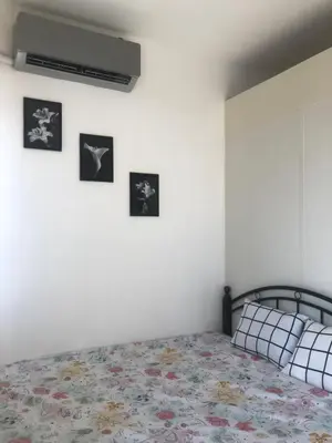 a bedroom with a bed with four pictures on the wall at SOUTH Residence Condotel in Manila
