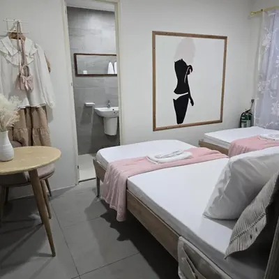 two beds in a room with a bathroom at Coquette vibes close to Cubao's Araneta Center in Manila