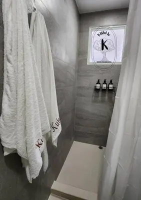 a bathroom with white towels hanging on a wall at Coquette vibes close to Cubao's Araneta Center in Manila