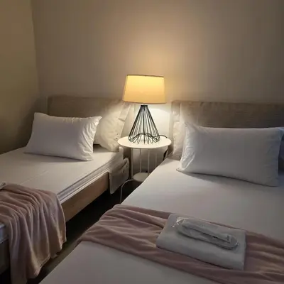 two beds in a room with a lamp on a table at Coquette vibes close to Cubao's Araneta Center in Manila