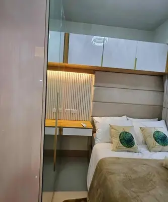 a small bedroom with a bed and a desk at Cozy apartment near Airport in Shore 3 in Manila