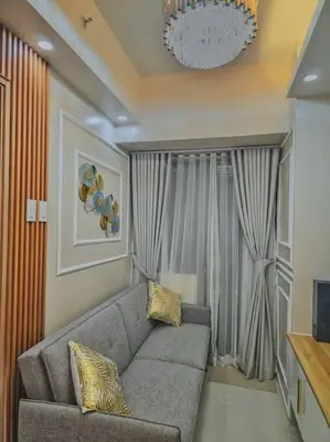a living room with a couch and a window at Cozy apartment near Airport in Shore 3 in Manila