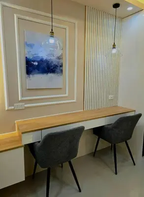 a desk with two chairs and a picture on the wall at Cozy apartment near Airport in Shore 3 in Manila