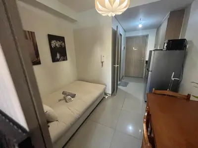 a small living room with a couch and a refrigerator at Shore 2 2-Bed Balcony City View WiFi Netflix near MOA 834 in Manila