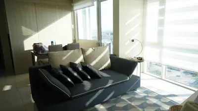 a blue couch in a living room with windows at SM Breeze one bedroom in Manila
