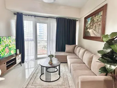 a living room with a couch and a table at 2 Bedrooms & 2 Bathrooms at BGC Taguig McKinley by Venice Grand Canal mall in Manila