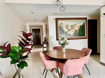 a dining room with a table and pink chairs at 2 Bedrooms & 2 Bathrooms at BGC Taguig McKinley by Venice Grand Canal mall in Manila