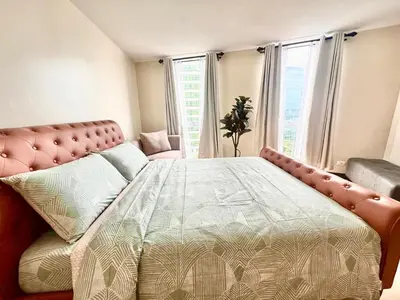 a bedroom with a large bed and a window at 2 Bedrooms & 2 Bathrooms at BGC Taguig McKinley by Venice Grand Canal mall in Manila