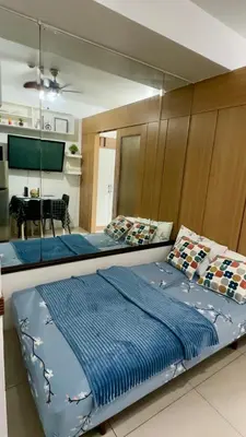 a bedroom with two beds and a dining room at Kathys Crib with balcony Pool view at Shell Residence in Manila
