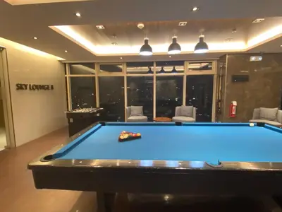 a pool table in a living room with a pool at Coast Residences Near MOA and NAIA Manila Bay View with Pool in Manila