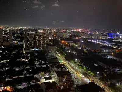a city lit up at night with traffic at Coast Residences Near MOA and NAIA Manila Bay View with Pool in Manila