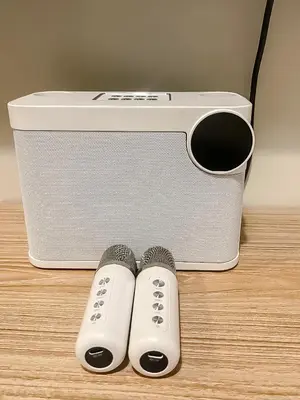 two remote controls sitting next to a speaker at Coast Residences Near MOA and NAIA Manila Bay View with Pool in Manila