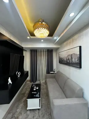 a living room with a couch and a chandelier at Bachelor Pad Shore 3 Residences in Manila