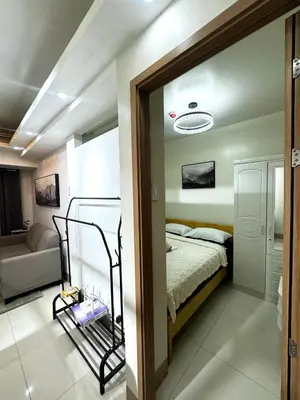 a bedroom with a bed and a living room at Bachelor Pad Shore 3 Residences in Manila
