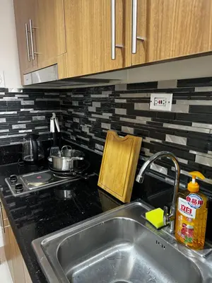 a kitchen counter with a sink and a stove at Bachelor Pad Shore 3 Residences in Manila