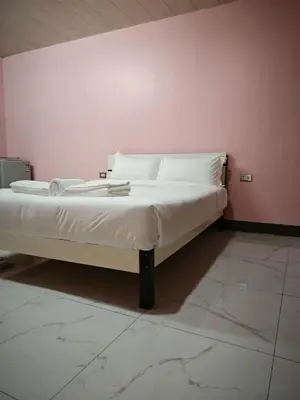 a bed with white sheets and pillows in a room at cartimar hotel condo in Manila