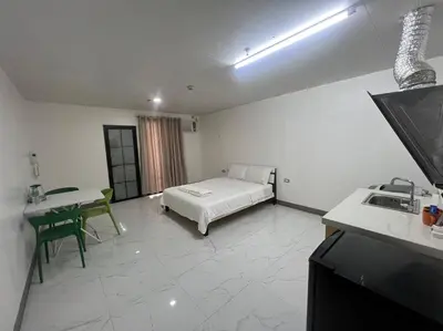 a bedroom with a bed and a table and a sink at cartimar hotel condo in Manila