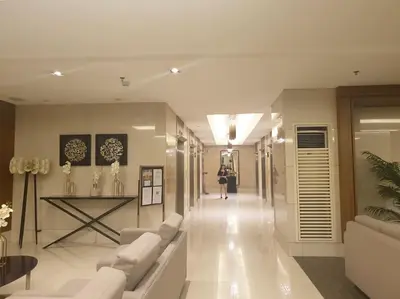 a living room with white couches and a table at SkyViewCondotel Breeze Residences Staycation near WTC,PICC,MOA,NAIA,OCEAN PARK in Manila